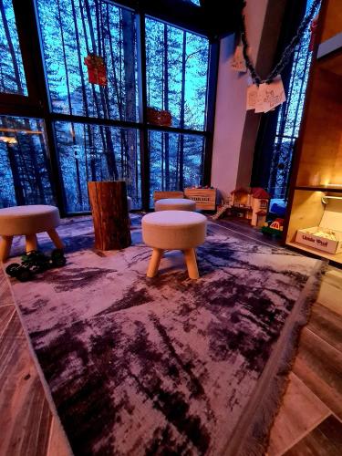 a room with three stools on a purple rug at Вила АРБОРЕТУМ in Teteven