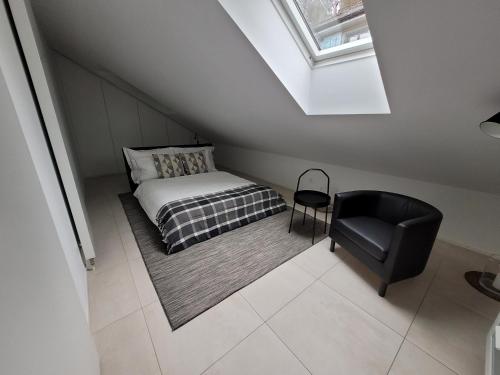 ein kleines Schlafzimmer mit einem Bett und einem Stuhl in der Unterkunft Zürich Niederdorf - Grossmünster in Zürich