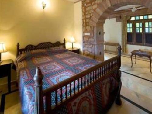 1 dormitorio con cama de madera en una habitación en Chandelao Garh, en Bīnāwās