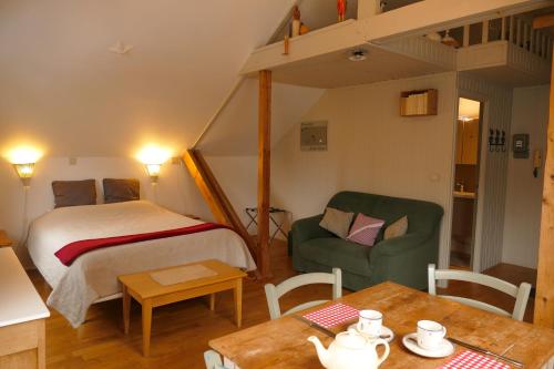 a bedroom with a bed and a chair and a table at La Pommeraie - Le Coin Ardenne in Sainte-Ode