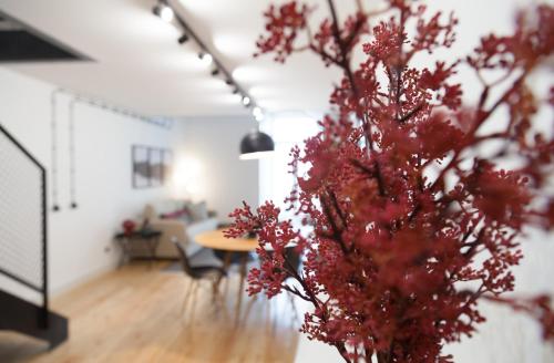 a room with a table and a vase with red flowers at FLH Intendente Industrial Design Duplex in Lisbon