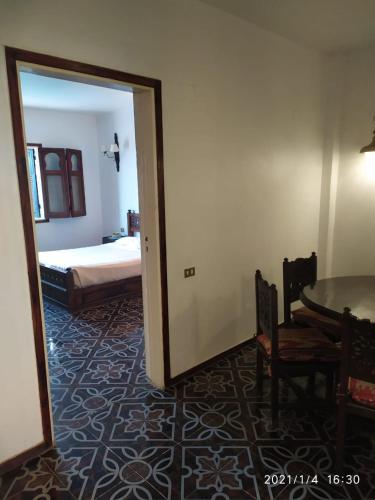 a room with a bed and a table and a mirror at Six Corners Resort in Abū Sulţān