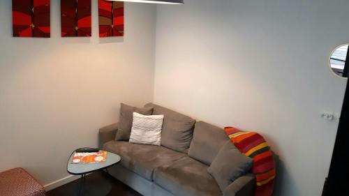a living room with a couch and a table at Burdigala Homes - Les Apparts de la Course in Bordeaux