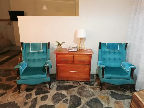 two blue chairs sitting next to a wooden dresser at MacNut Bed and Breakfast in Nelspruit