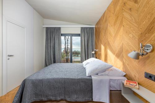 a bedroom with a large bed and a window at Villa Voliera, Papafigo Camping in Vodnjan