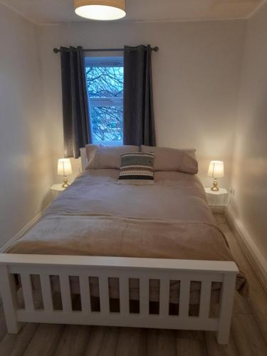 a bedroom with a large bed with a window at Comfortable 2 Bed Apartment 2nd Floor Contractors Families Close To City Centre Occasional Bed Available in Coventry