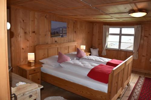 Cette chambre en bois comprend un grand lit. dans l'établissement Ferienhaus Brittenberg, à Schwarzenberg im Bregenzerwald