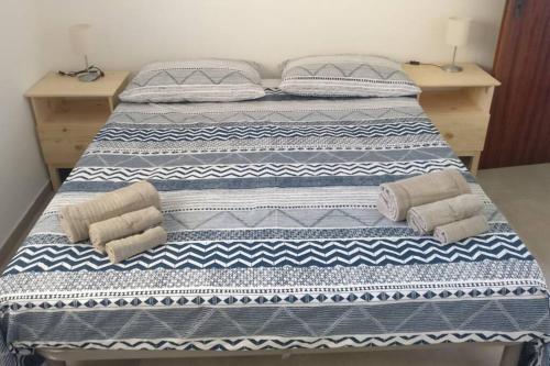 1 cama con 2 almohadas y toallas en Il Giglio di mare, en San Saba
