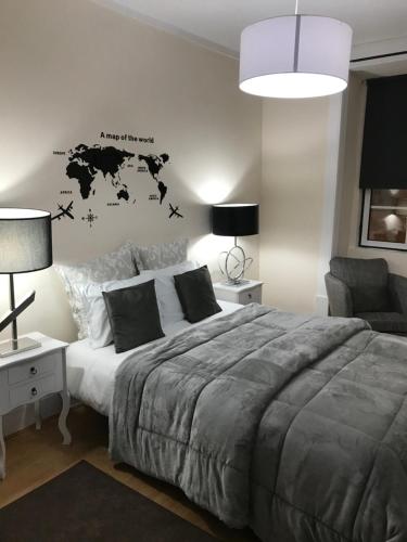 a bedroom with a large bed and a desk and a chair at Miguel Torga Typical in Coimbra
