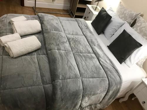 a large bed with white sheets and black pillows at Miguel Torga Typical in Coimbra
