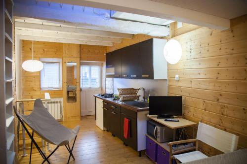 - une cuisine avec des murs en bois, une table et une cuisinière dans l'établissement La Tiny, à Beure