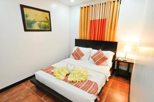 a white bed with two pillows on it in a room at Paradise Garden Hotel and Convention Center Boracay Powered by ASTON in Boracay