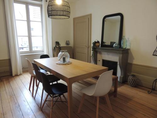 a dining room table with chairs and a mirror at Le Breuil - Spacieux, Chaleureux, Emplacement Idéal in Vesoul