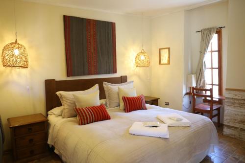 a bedroom with a large white bed with red pillows at Terrace Lodge in Putre