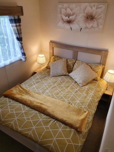 a bed in a bedroom with two lamps on it at Relaxing Breaks with Hot tub at Tattershal lakes 3 Bedroom in Tattershall