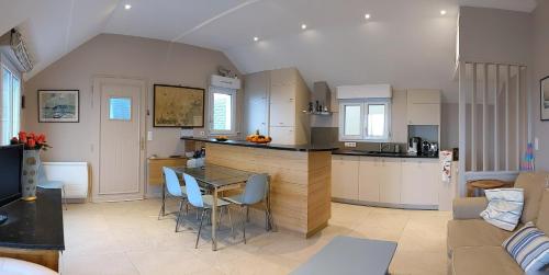 a kitchen and living room with a table and chairs at La Conchee in Saint Malo