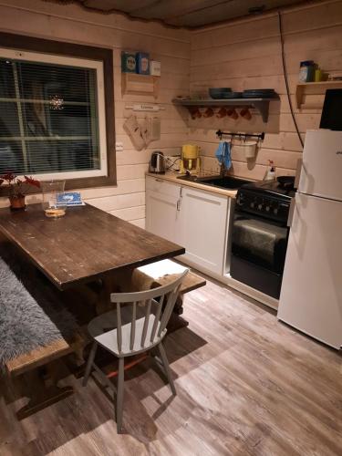 een keuken met een tafel en een koelkast bij Kärrända in Nedervetil