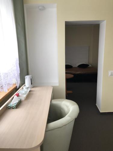 a room with a desk with a chair and a bedroom at La-Vanda in Šiauliai