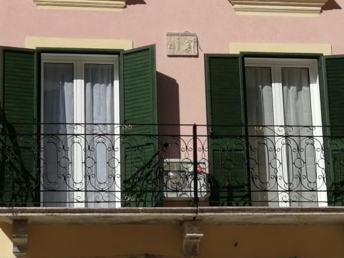 two windows with green shutters on a balcony at Appartamento centralissimo in Castellammare del Golfo