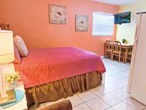 1 dormitorio con 1 cama y comedor en Bella Sirena Inn en St Pete Beach