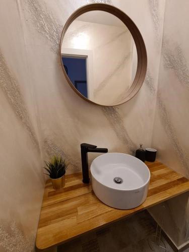 a bathroom with a white sink and a mirror at Apartament Central Iulia in Sibiu