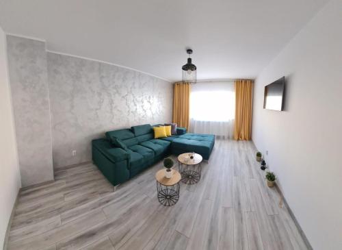 a living room with a green couch and a table at Apartament Central Iulia in Sibiu