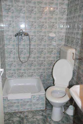 a bathroom with a toilet and a bath tub at Hotel Merkur in Miercurea-Ciuc