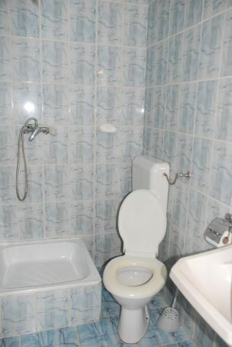 a bathroom with a toilet and a tub and a sink at Hotel Merkur in Miercurea-Ciuc