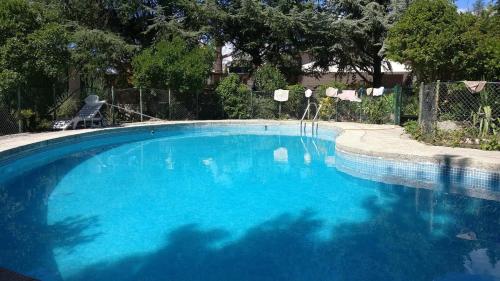a large pool with blue water in a yard at La Casita de Chozas in Soto del Real