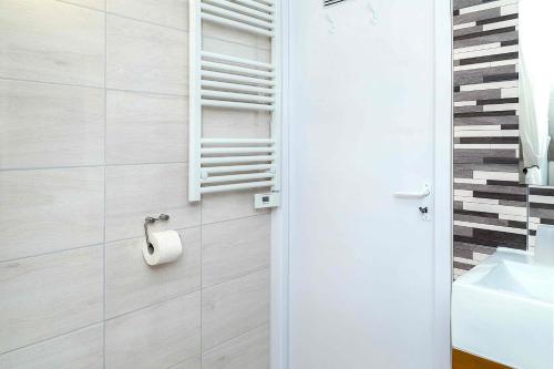 Baño con papel higiénico en la pared en Green Stone Apartments, en Hajdúszoboszló