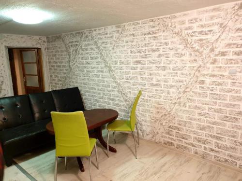 a room with a brick wall with a table and chairs at 2 стаен до парка in Razgrad