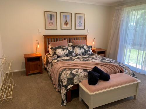 a bedroom with a bed and two lamps and a window at Kurow House on Bledisloe - A2O Cycle Trail Oasis. in Kurow