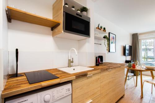uma cozinha com um lavatório e uma máquina de lavar louça em Amazing studio 2P - Buttes Chaumont em Paris