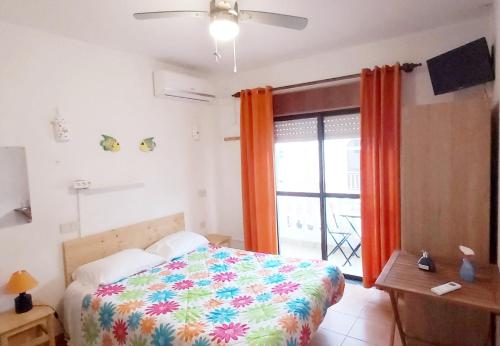 a bedroom with a bed and a large window at Residencia do Parque in Odeceixe