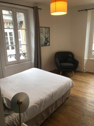 une chambre avec un lit, une chaise et une fenêtre dans l'établissement Spacieux T3 en hyper centre, à Quimper