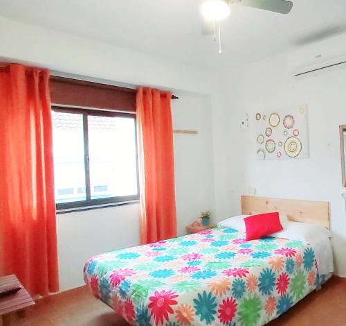 a bedroom with a colorful bed and a window at Residencia do Parque in Odeceixe