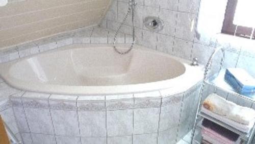 格平根的住宿－麥克公寓，带窗户的浴室内的白色浴缸