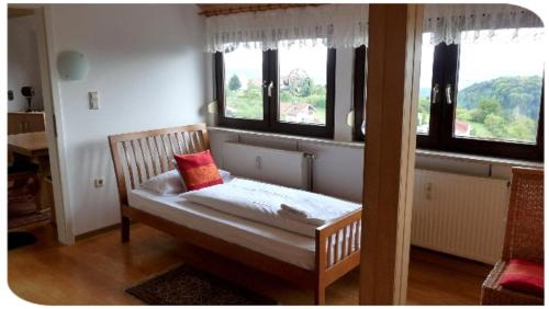 a small bed in a room with windows at Ferienwohnung Mack in Göppingen