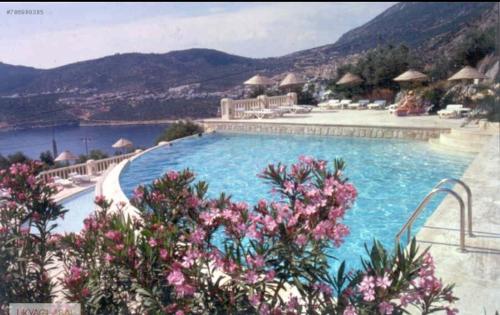 a large swimming pool with mountains in the background at Sea view Bougainvillea 52 in Kalkan