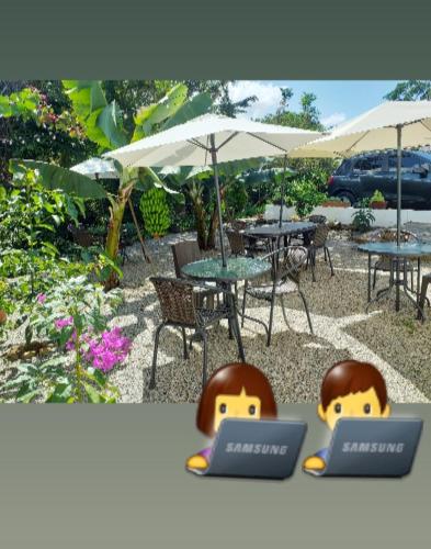 two tables with umbrellas and tables with laptops on them at Casona CHARA in Barichara