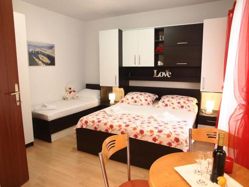 ein Hotelzimmer mit zwei Betten und einem Tisch in der Unterkunft Apartman Mario in Makarska