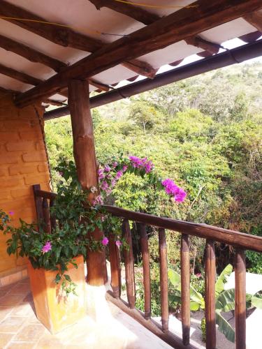 a balcony with flowers and a wooden railing at Casona CHARA in Barichara