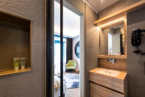 a bathroom with a sink and a mirror at Palace Hotel Zandvoort in Zandvoort