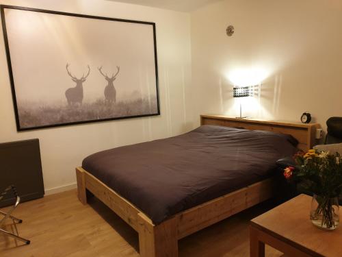 een slaapkamer met een bed met een foto van herten aan de muur bij Studio "Shoshana" Harderwijk in Harderwijk