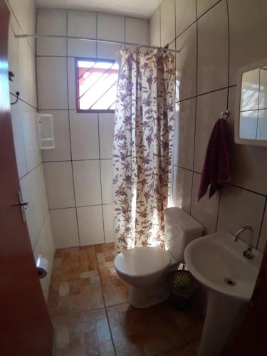 a bathroom with a toilet and a sink at Pousada Natureza in São Thomé das Letras