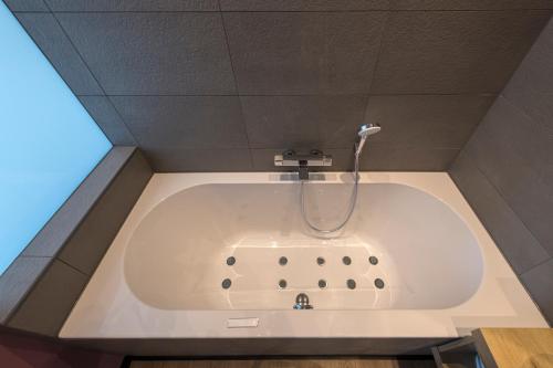 
a bathroom with a sink and a bath tub at Palace Hotel Zandvoort in Zandvoort
