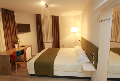 Habitación de hotel con cama y escritorio en Hotel-Restaurant Entrada en Bielefeld
