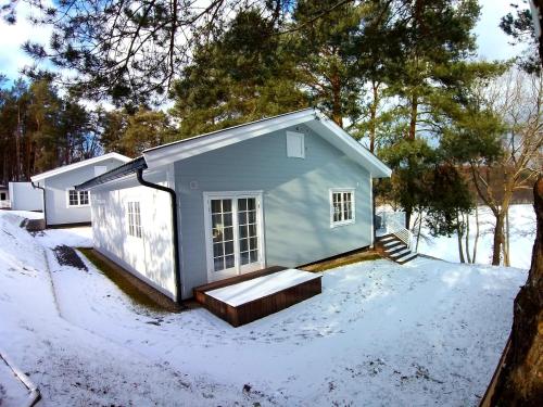 a small house with snow on the ground at Przystań na Zagórzu - Apartamenty nad jeziorem in Drezdenko