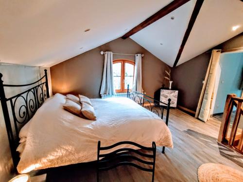 貝萊的住宿－La Maison cachée du PAVILLON BELLEVUE，一间卧室设有一张大床和一个窗户。