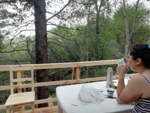 a woman sitting at a table talking on a cell phone at Las Zarinas 4 in Trapiche